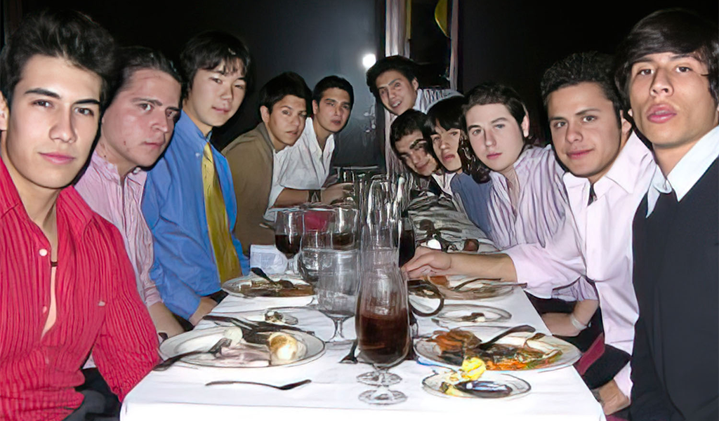 a group of people sitting at a table with food